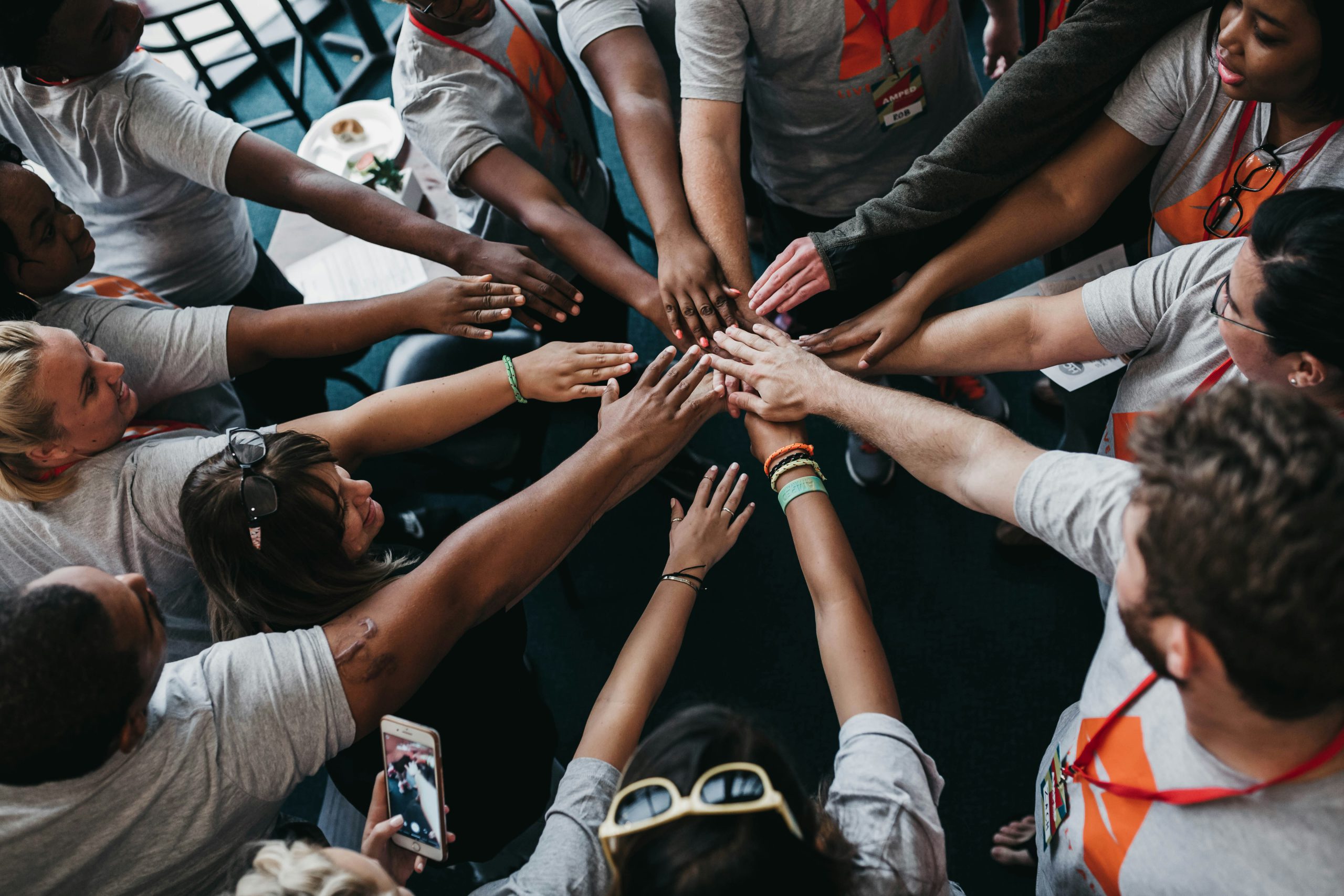 People with hands gathered in the middle symbolizing teamwork